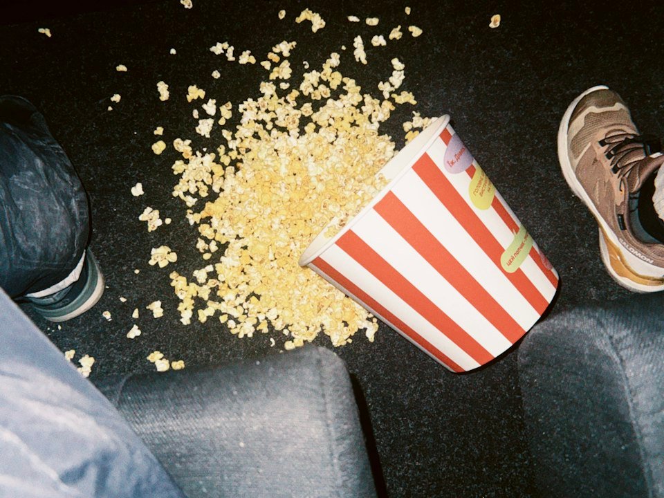 Spilled popcorn bucket on a movie theatre floor